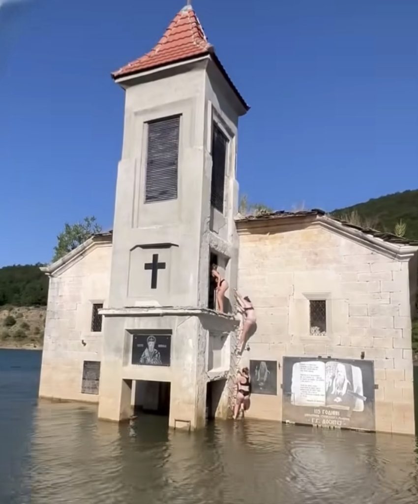 (ВИДЕО) Туристи по костими за капење се качувале по црквата „Св. Никола“ во Маврово – јавноста бара итна реакција